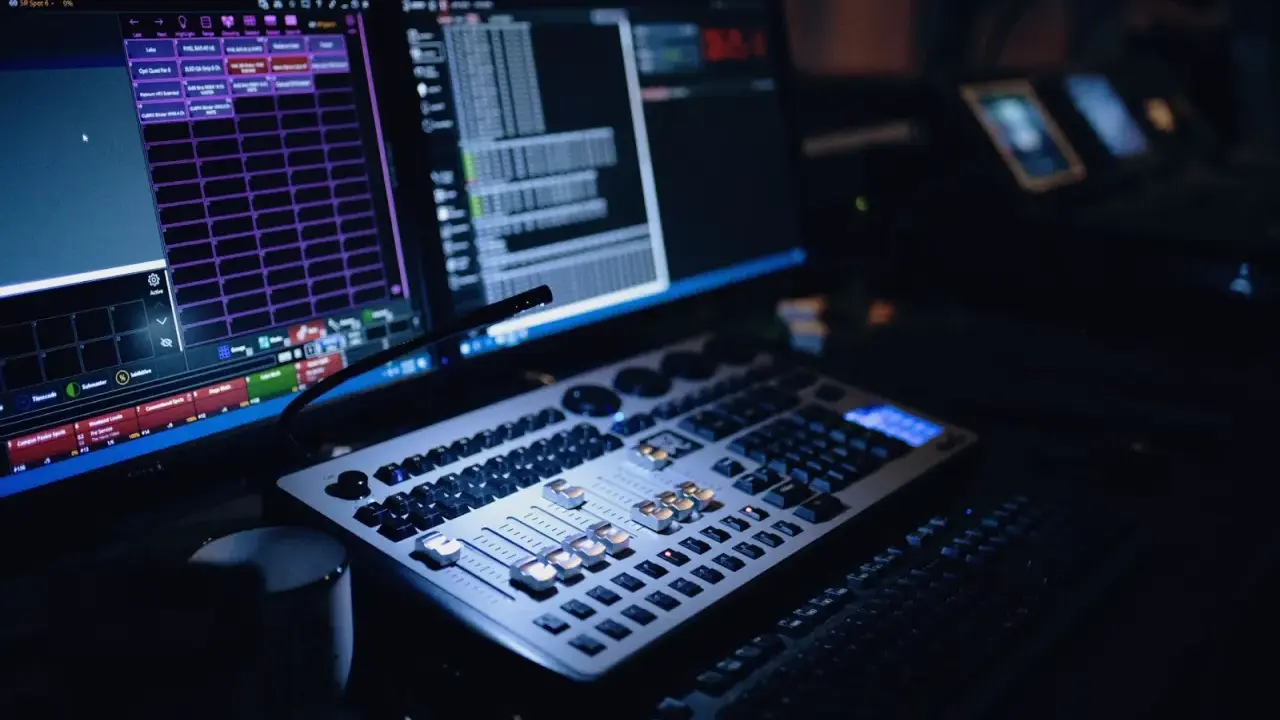 Console de mixage et écrans d'ordinateur, le **mao signification** est ici le contrôle de la lumière et du son pour un spectacle.