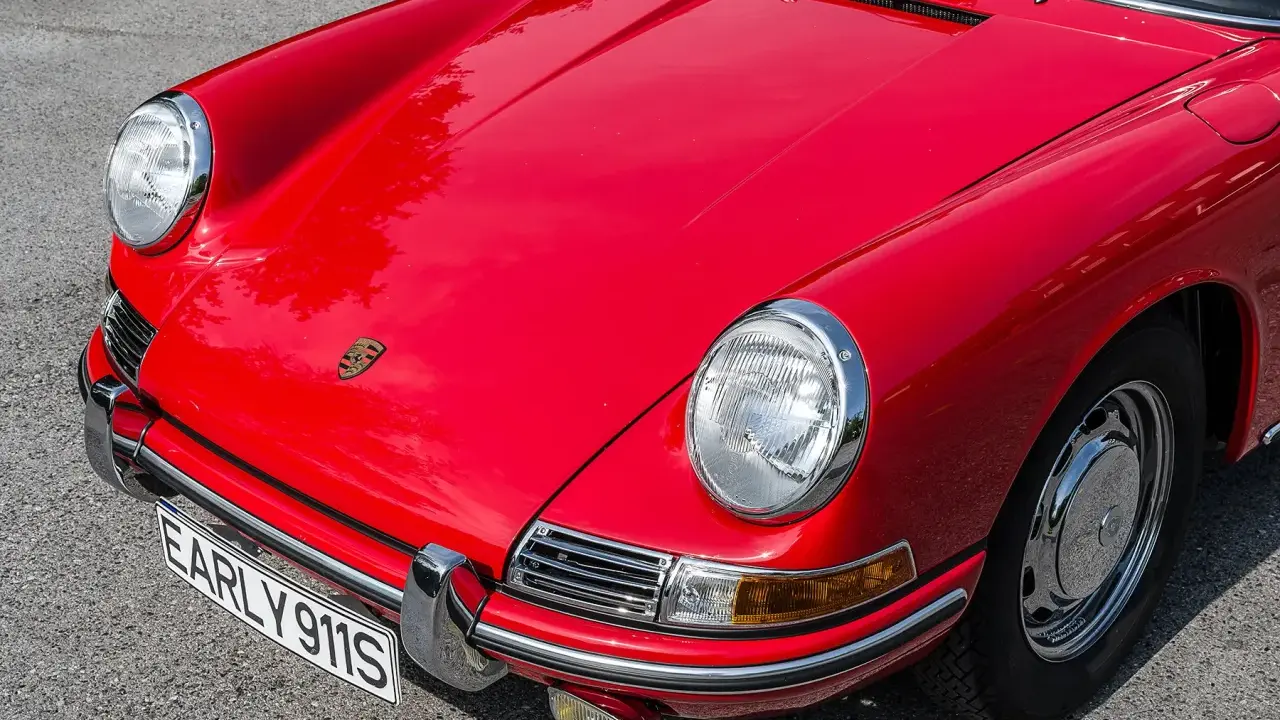 Roter Porsche 901, ein Klassiker mit hohem Wert. Die Front zeigt das Porsche-Logo und die Kennzeichenplatte "EARLY 911S".