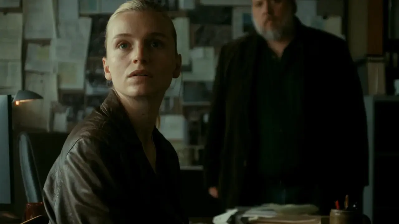 Kobieta w skórzanej kurtce i mężczyzna z brodą w tle, atmosfera napięcia w stylu thriller skandynawski film.