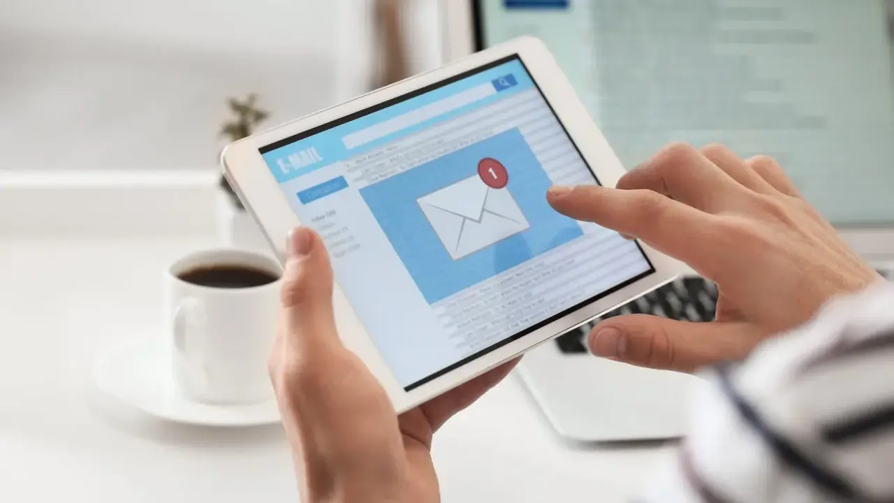 Osoba przegląda e-mail po angielsku na tablecie, szukając przykładów wiadomości.