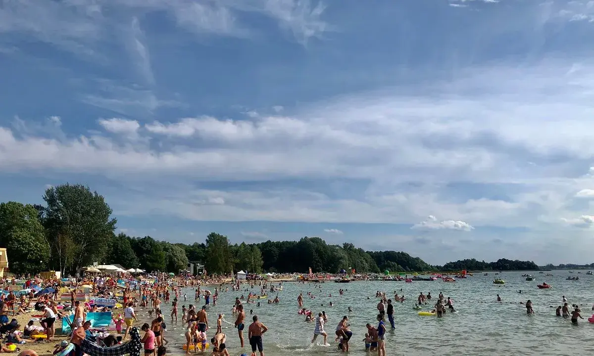 Tłumy ludzi korzystają z kąpieliska w Skorzęcin, ciesząc się słońcem i wodą. To popularne miejsce oferuje wiele atrakcji dla każdego.