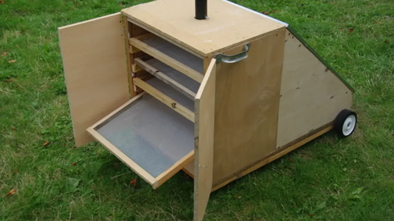 Un sechoir solaire diy en bois, avec des étagères et une porte ouverte sur un tamis. Idéal pour sécher des herbes ou des fruits au soleil.