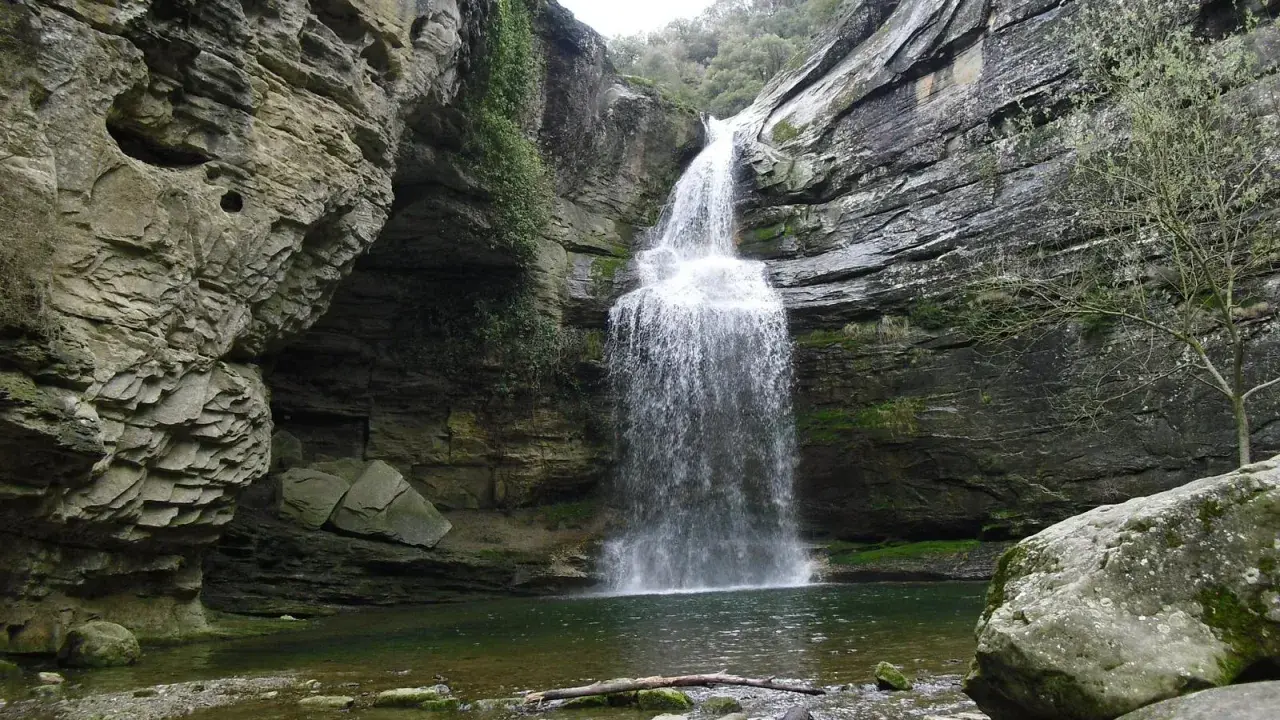 La Foradada en Cantonigròs, una cascada espectacular rodeada de rocas y vegetación, creando un paisaje natural impresionante.