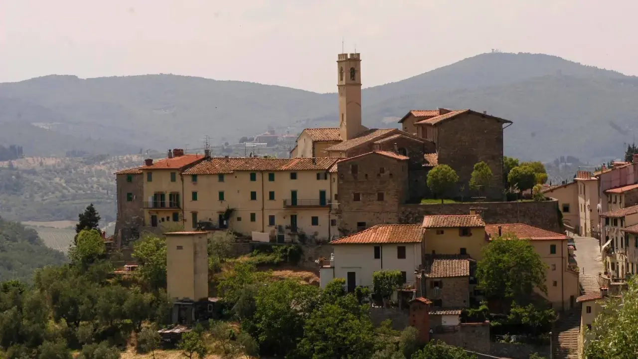 Borgo toscano con campanile, un luogo da film, dove la storia incontra la bellezza paesaggistica.