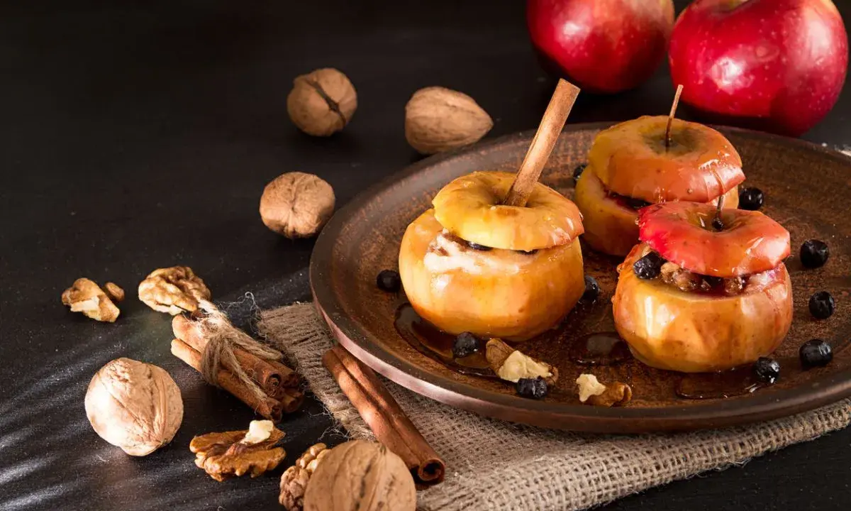 Deliciosas manzanas asadas con canela, nueces y arándanos, listas para disfrutar.