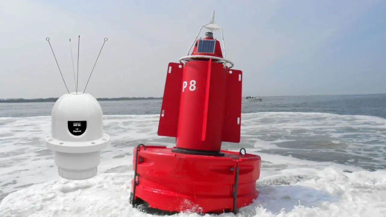 Deux bouées, une blanche avec des antennes et une rouge marquée "P8", flottent sur l'eau agitée, un petit bateau à l'horizon.