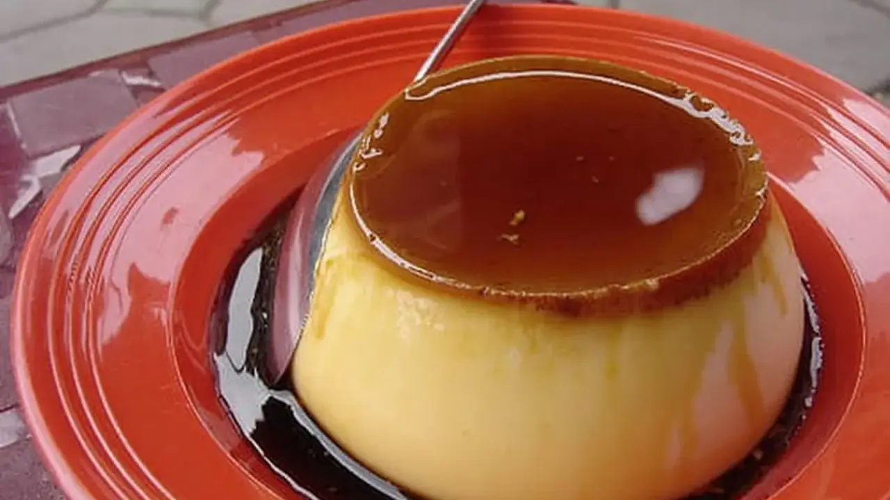 Un délicieux crème caramel, tout juste sorti du four, prêt à être dégusté. Sa texture onctueuse et son caramel doré invitent à la gourmandise.