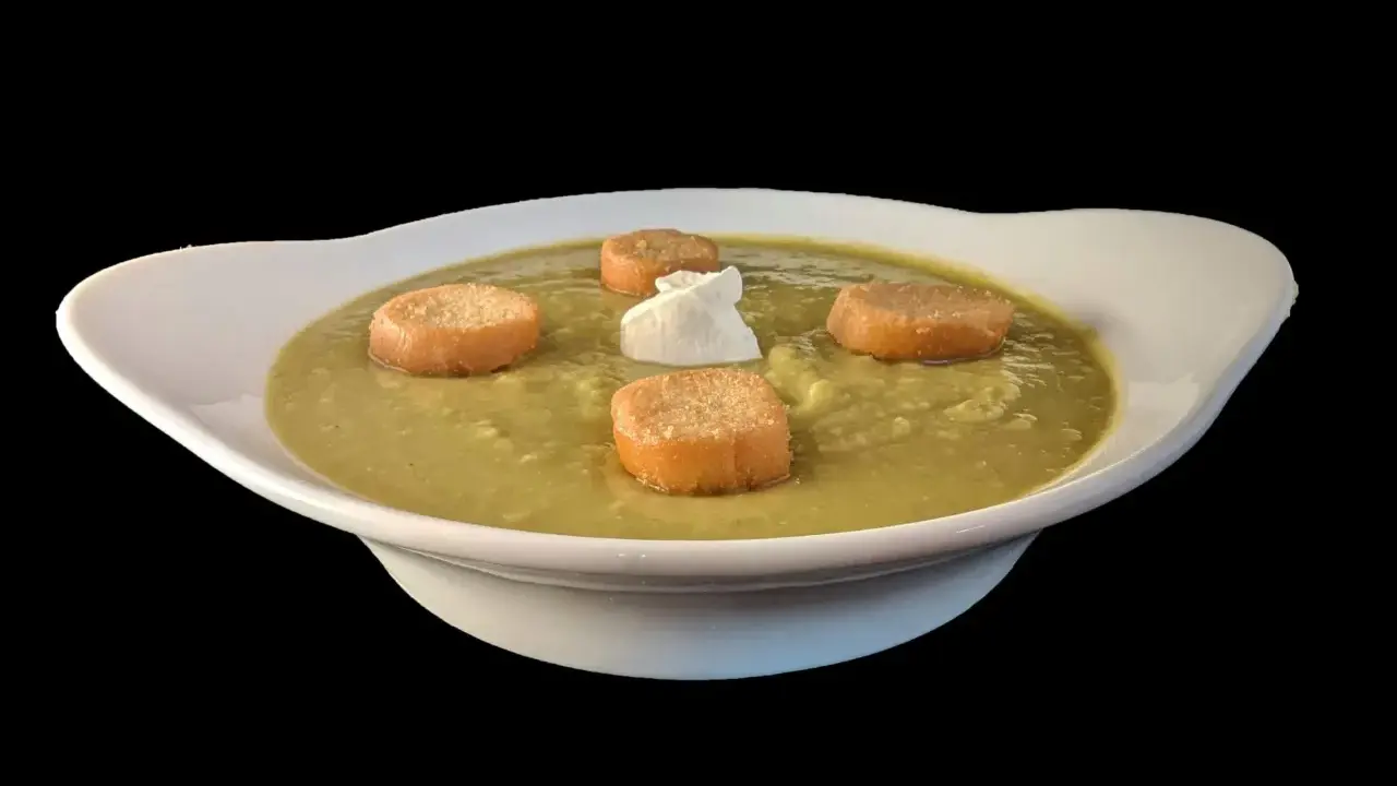 Soupe de pois cassés onctueuse, garnie de croûtons dorés et d'une touche de crème. Un délice réconfortant.