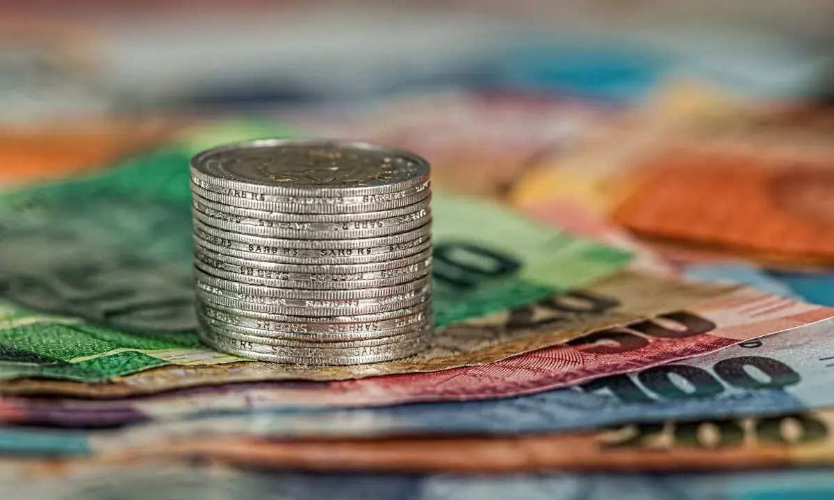 Stos monet na kolorowych banknotach. Czy to symbol najlepiej płatnych zawodów w Norwegii?
