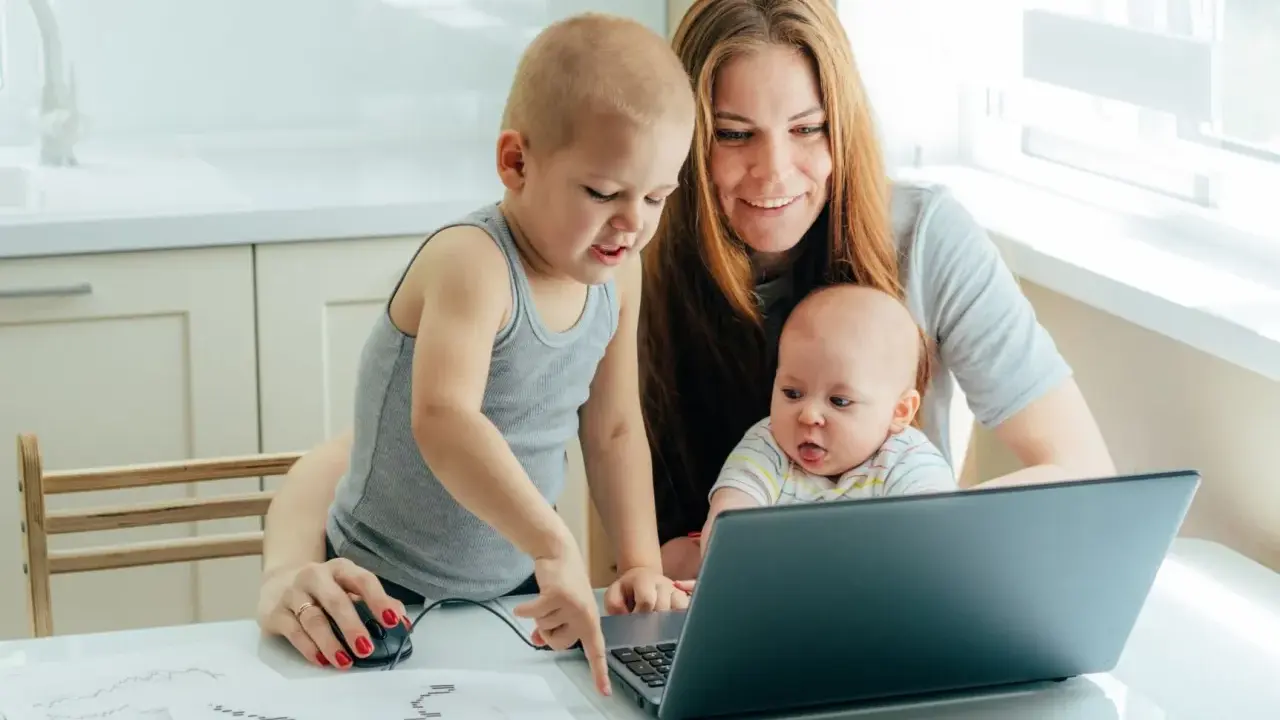 Mama z dwójką dzieci przy laptopie, starszak pokazuje coś na ekranie. To ich wspólny artystyczny projekt, może nawet z elementami art 188 kp.