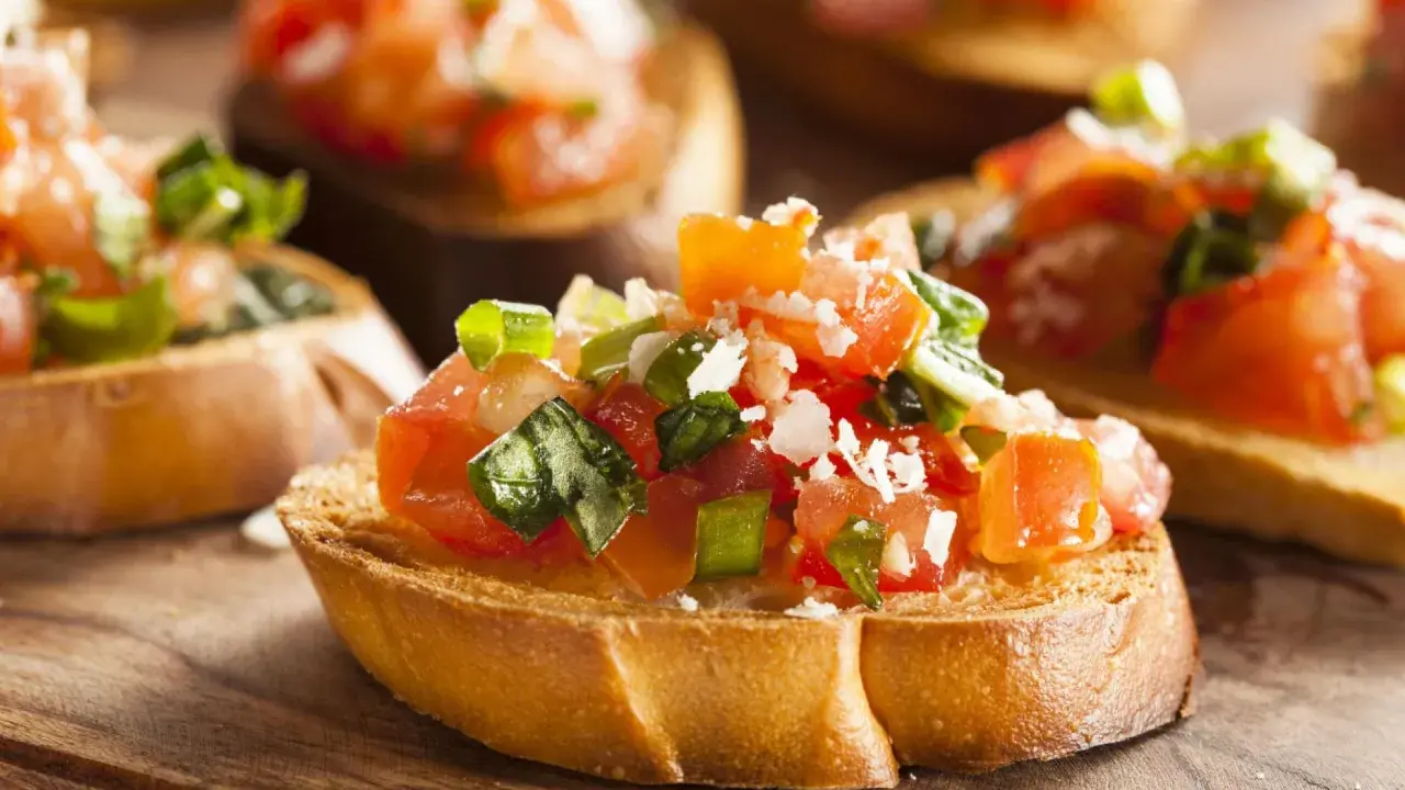 Frisch zubereitetes Bruschetta, ein klassisches italienisches Rezept, mit Tomaten, Basilikum und Parmesan auf geröstetem Brot.