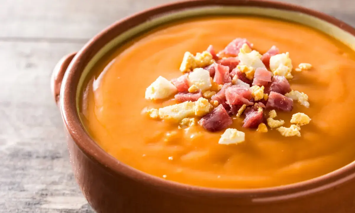 Un cuenco de salmorejo, la deliciosa comida típica de Córdoba, adornado con trocitos de huevo duro y jamón serrano.