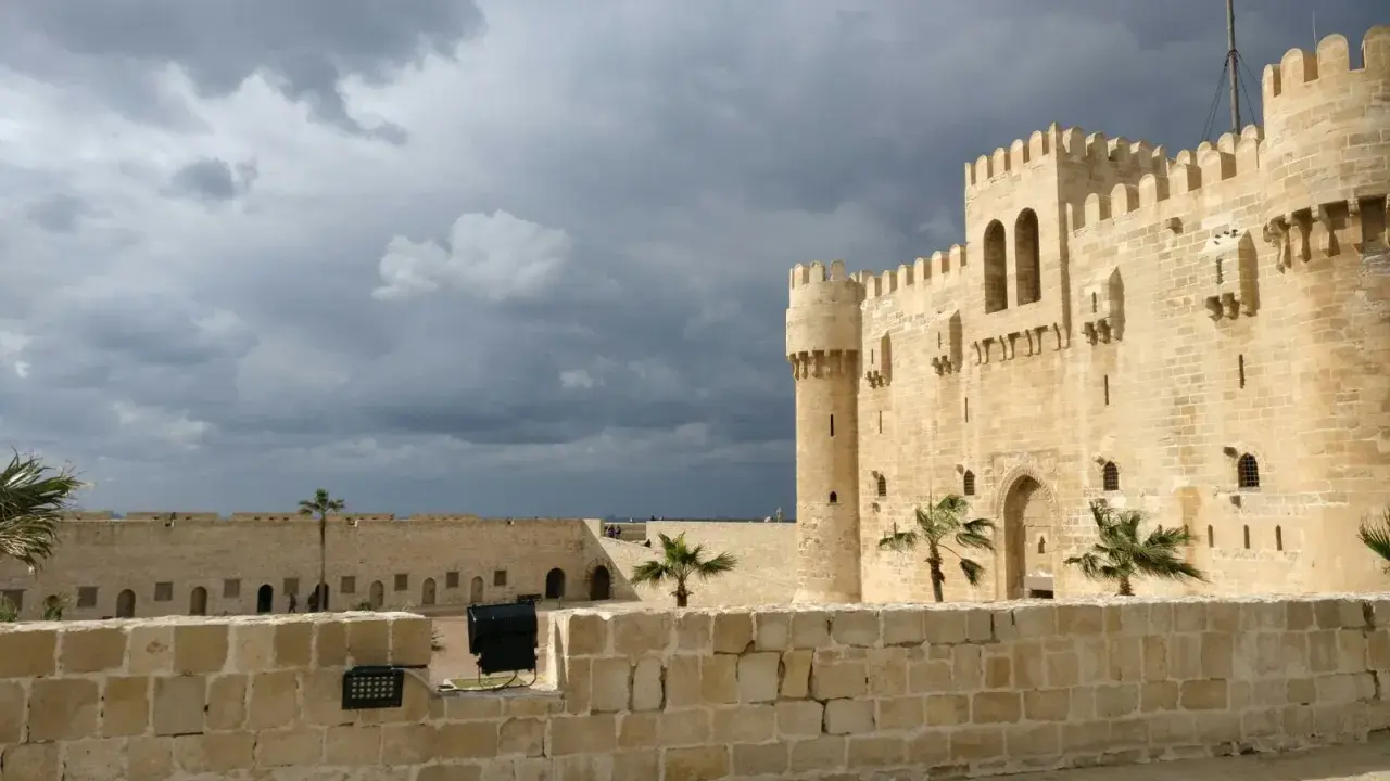 Die Zitadelle von Qaitbay in Aleksandria, Ägypten, ragt unter einem dramatischen Himmel auf.