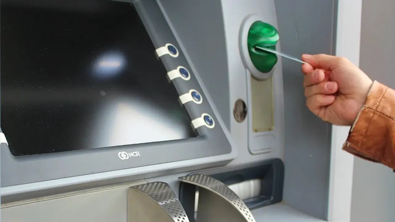 Mano insertando una tarjeta N26 extranjero en un cajero automático.