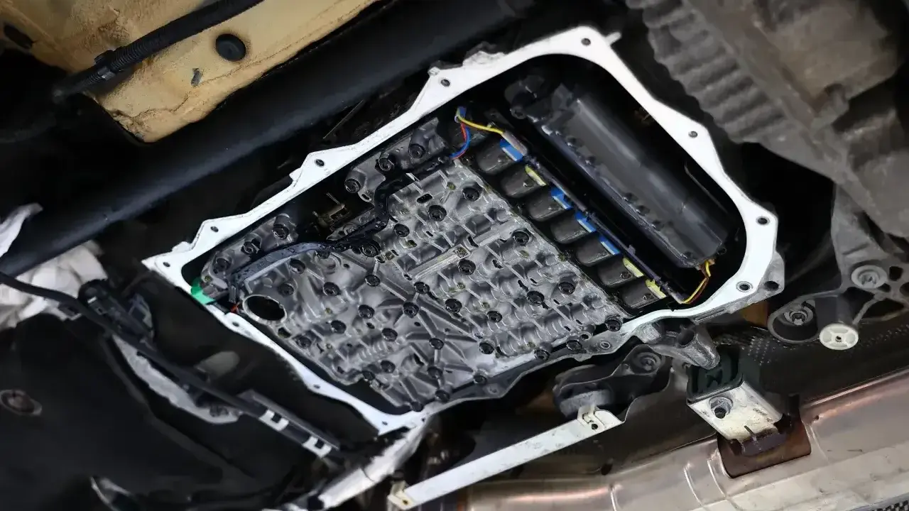 Widok od spodu na otwartą skrzynię biegów, gdzie widać skomplikowany mechanizm i cewki odpowiedzialne za płynny powershift.