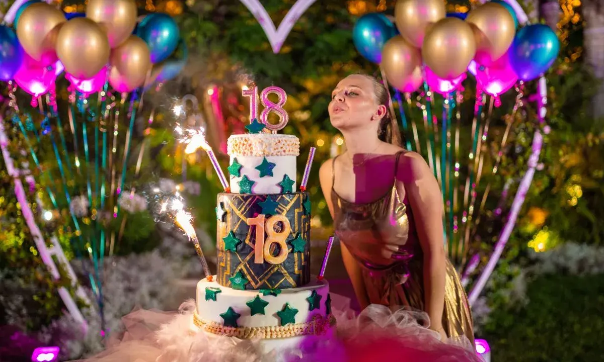 Dziewczyna zdmuchuje świeczki na tortcie z cyfrą 18, otoczona balonami i fajerwerkami. Idealne atrakcje na 18 urodziny!