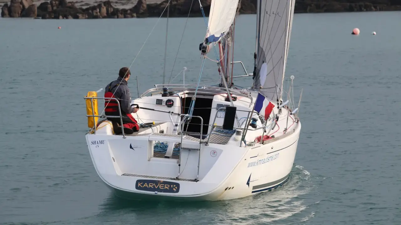 Un voilier Dufour 325 Grand Large navigue, un homme à la barre. Avis de navigation en mer.