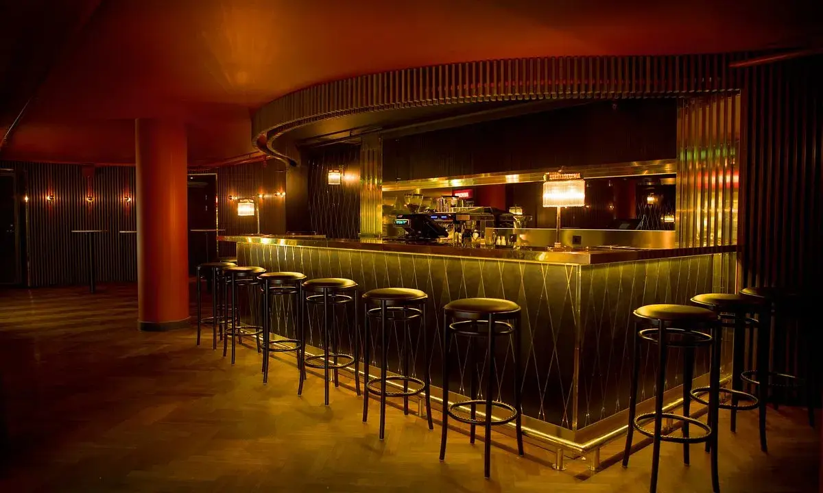 En elegant bar med gulddetaljer och barstolar, perfekt för en kväll på Rigoletto Stockholm.