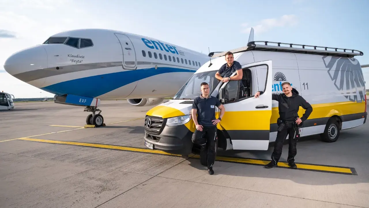 Trzech pracowników Enter Air stoi obok samolotu i vana. Chcesz wiedzieć, jak sprawdzić numer lotu Enter Air?
