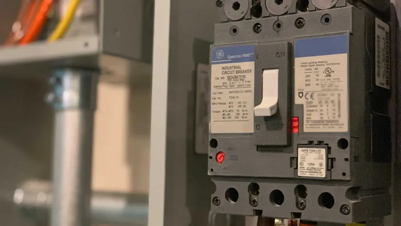 En industriell automatsäkring, redo att installera jordfelsbrytare. Kablar i orange, gult och grönt syns.
