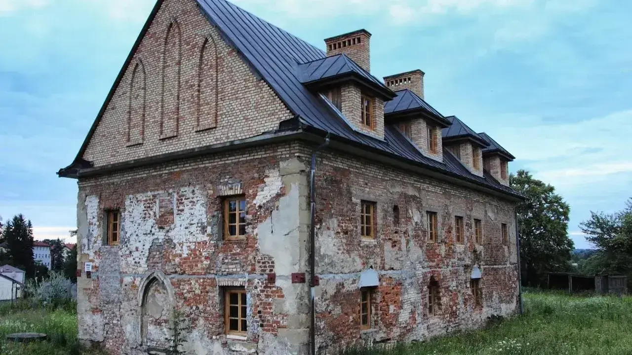 Stary budynek w Bieczu, zniszczony tynk, ceglane ściany, okna z drewnianymi ramami. Jedna z bieckich atrakcji, czekająca na renowację.