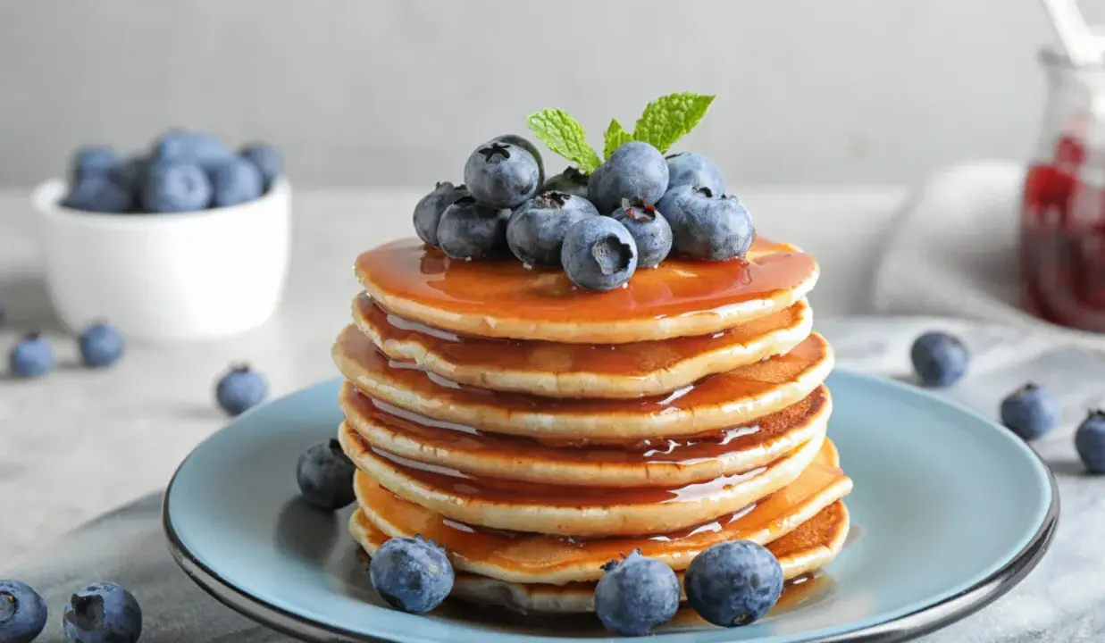 Pyszny stos naleśników z syropem i borówkami, idealny na śniadanie. Ten przepis na pancake zachwyci każdego!
