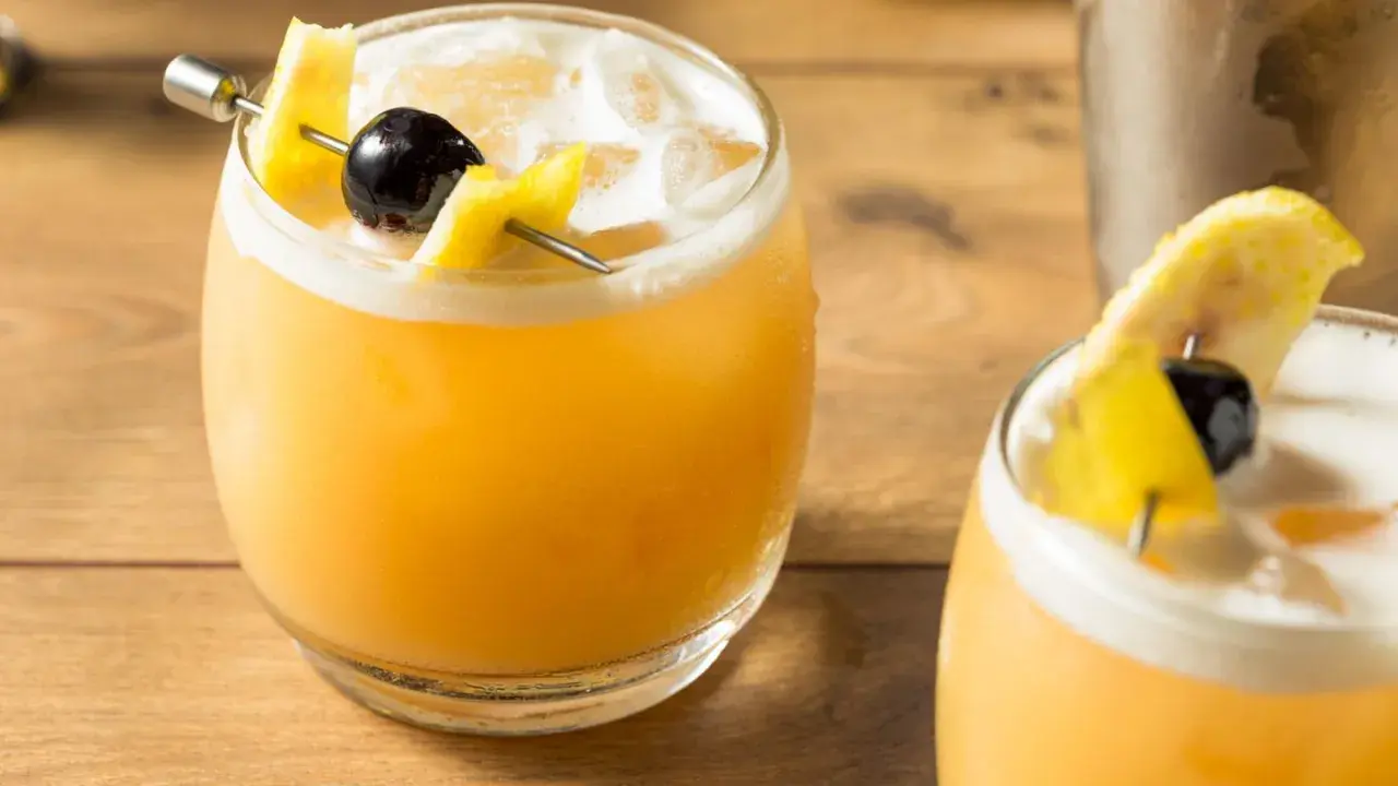 Zwei erfrischende Cocktails mit Zitronenzeste und Kirsche, perfekt für die Liste der 10 beliebtesten Cocktails.