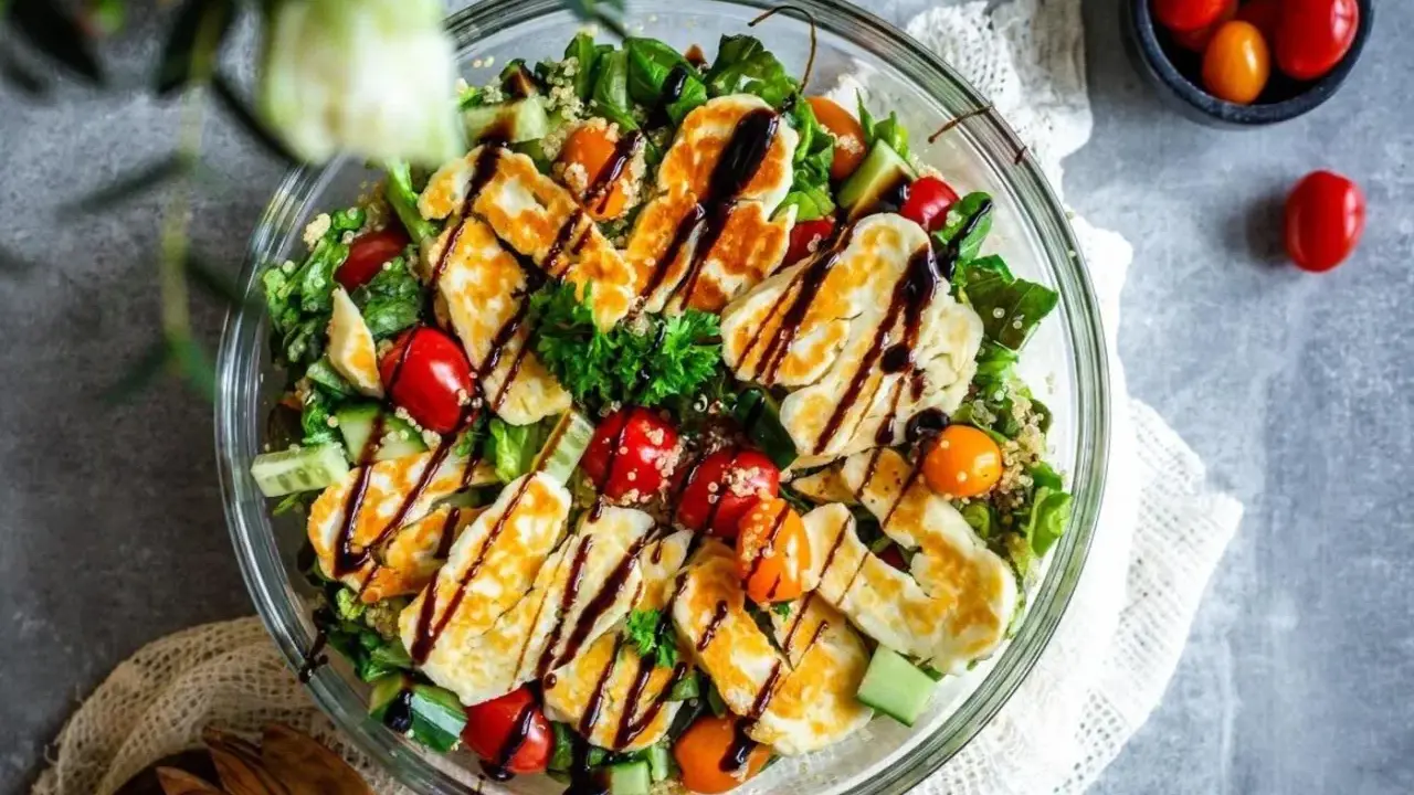 En härlig halloumi sallad med quinoa, körsbärstomater och gurka, ringlad med balsamvinäger. Perfekt för en lätt lunch.