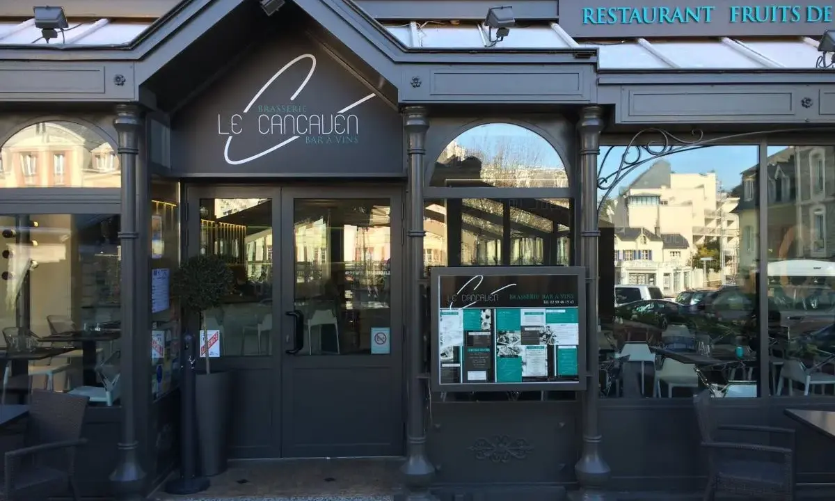 La façade de la meilleure brasserie Saint-Malo, "Le Cancaluen", avec son enseigne élégante et ses grandes vitrines reflétant la ville.