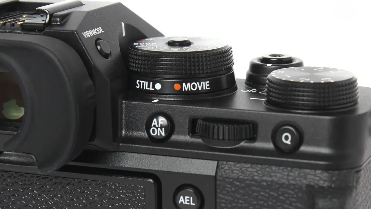 Część aparatu Fujifilm xt3 z pokrętłem wyboru trybu "STILL" i "MOVIE", przyciskiem "AF ON" i pokrętłem sterującym.