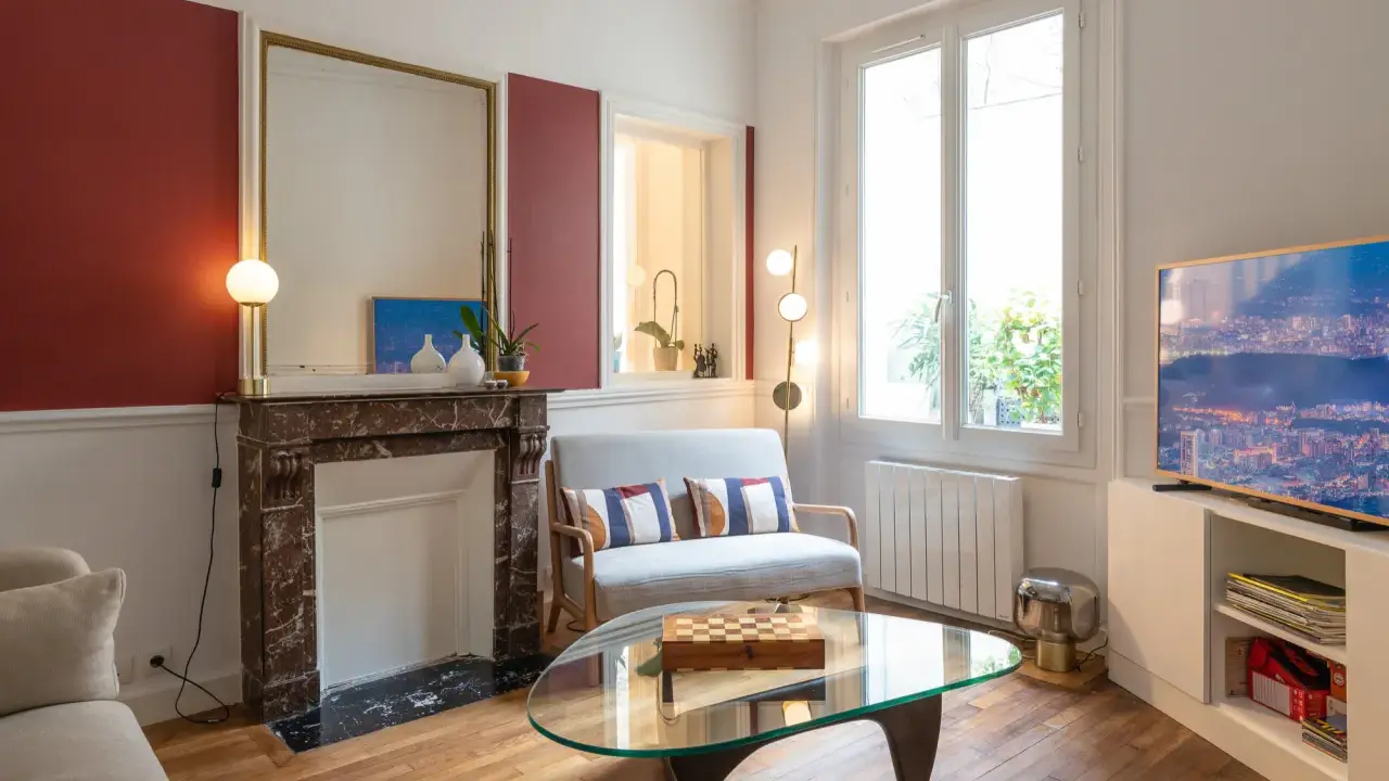 Plan salon 16m2 : cheminée en marbre, canapé gris, table basse en verre avec jeu d'échecs, fenêtre lumineuse.