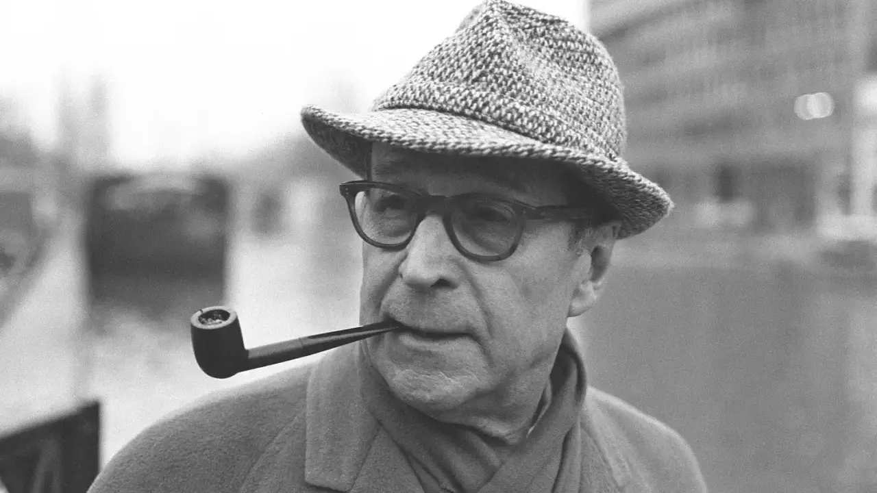 L'autore Georges Simenon con la pipa, un'immagine che evoca i suoi celebri maigret libri in ordine cronologico.