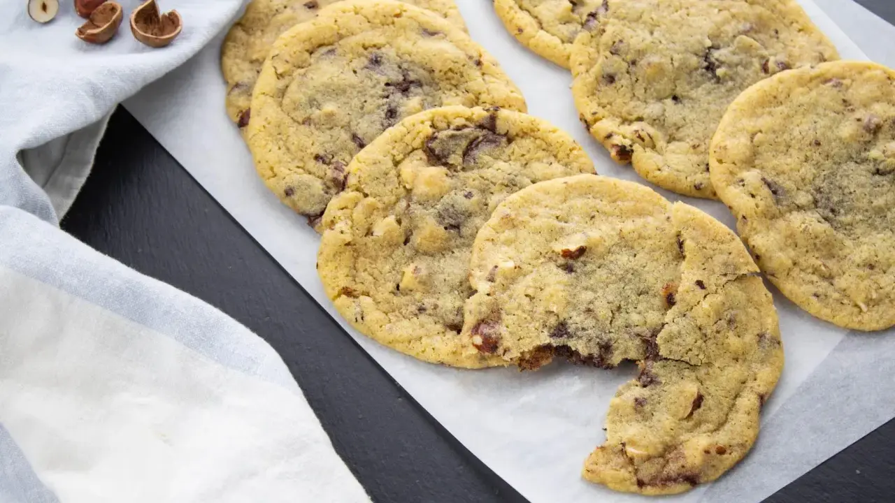 Gros plan sur des cookies aux pépites de chocolat et noisettes, dont le beurre fondu a donné une texture parfaite. Un délice !