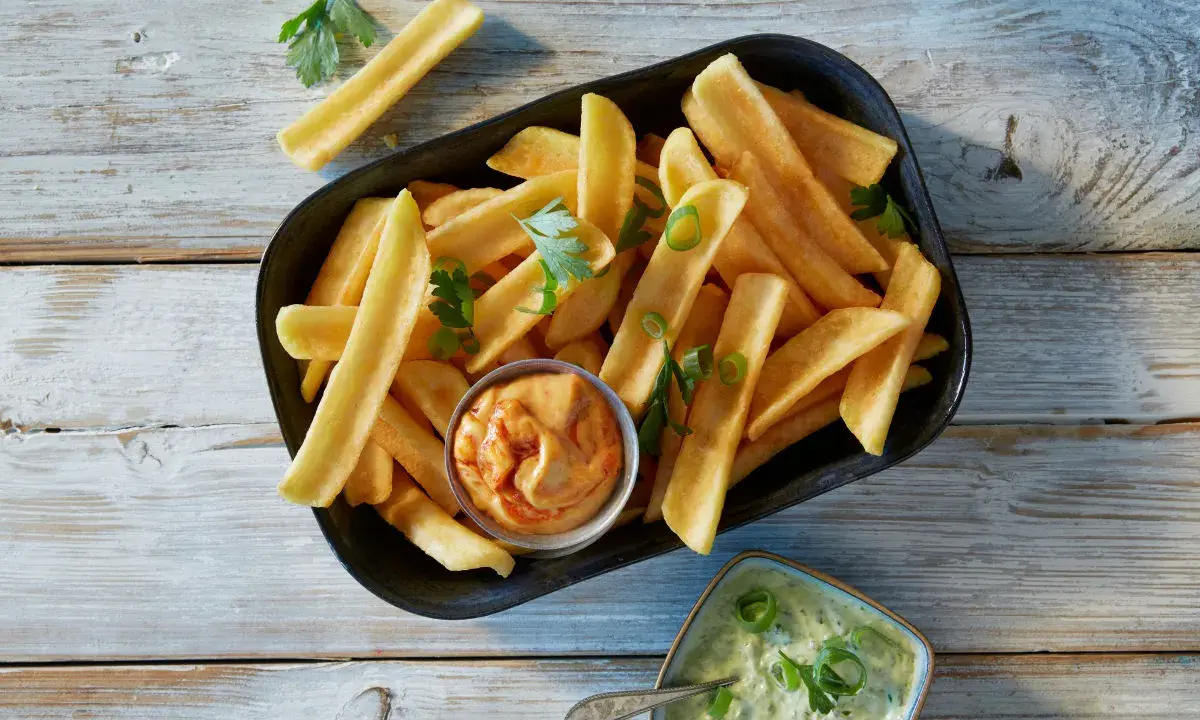 En skål med gyllene pommes frites, perfekt för att doppa i den krämiga såsen till pommes.