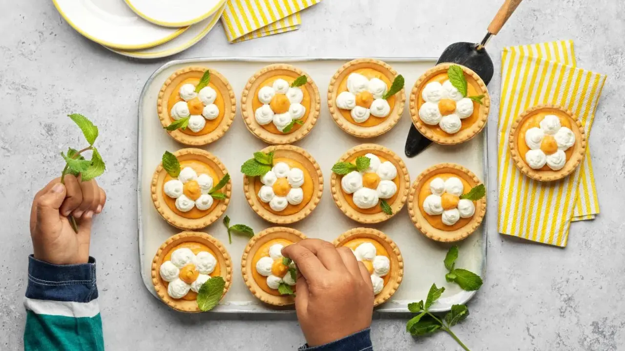 Douces tartelettes à l'abricot, décorées de crème fouettée et de menthe, prêtes à être dégustées.