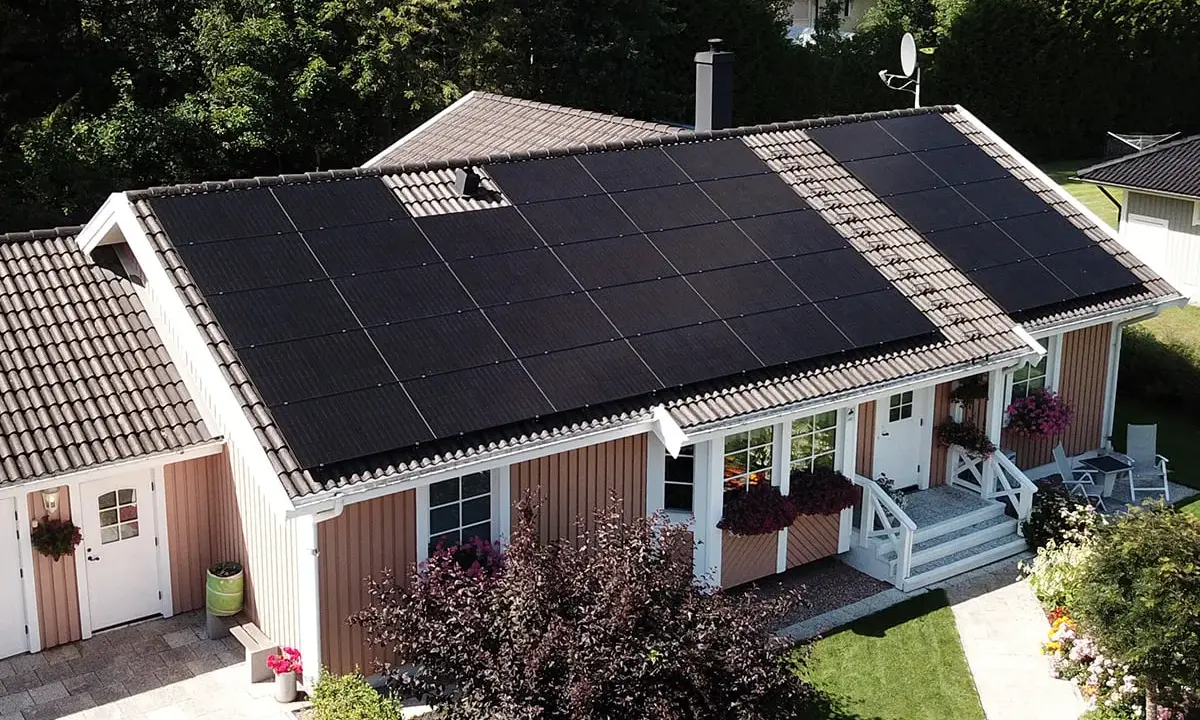 Ett svenskt hus med solpaneler på taket, en investering i solkraft AB för en grönare framtid.