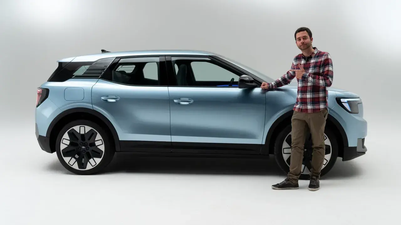 Hombre junto a un coche azul claro, mostrando las medidas del Ford Explorer.