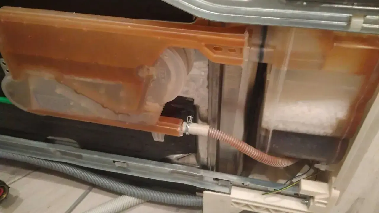 Zmywarka Electrolux z błędem i20. Widoczny zbiornik z brązową wodą i solą.