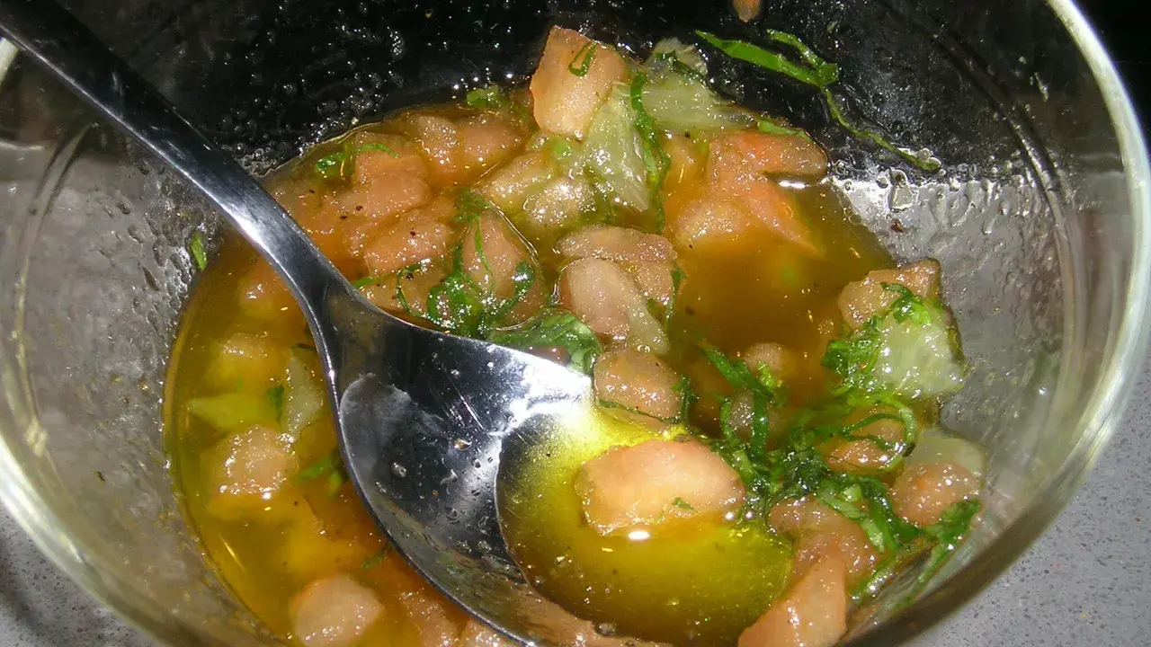 Sauce vierge fraîche avec des dés de tomate, des herbes et de l'huile d'olive, prête à accompagner un poisson.