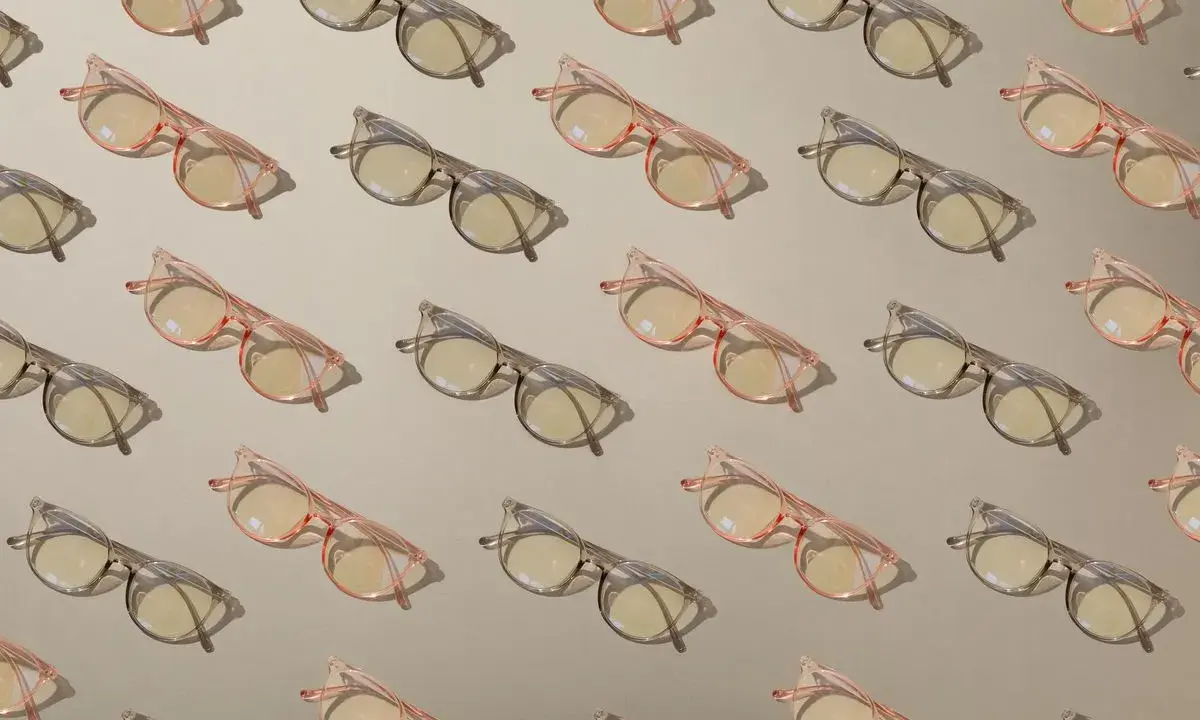 Różowe i szare okulary w kratkę, z soczewkami fotochromowymi. Zastanawiasz się nad fotochromy zalety i wady?