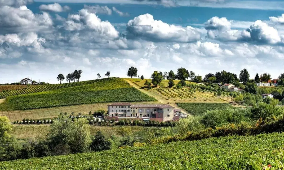 Un perfetto weekend nel Monferrato tra vigneti rigogliosi e colline dolci, con un casale in pietra che domina il paesaggio.