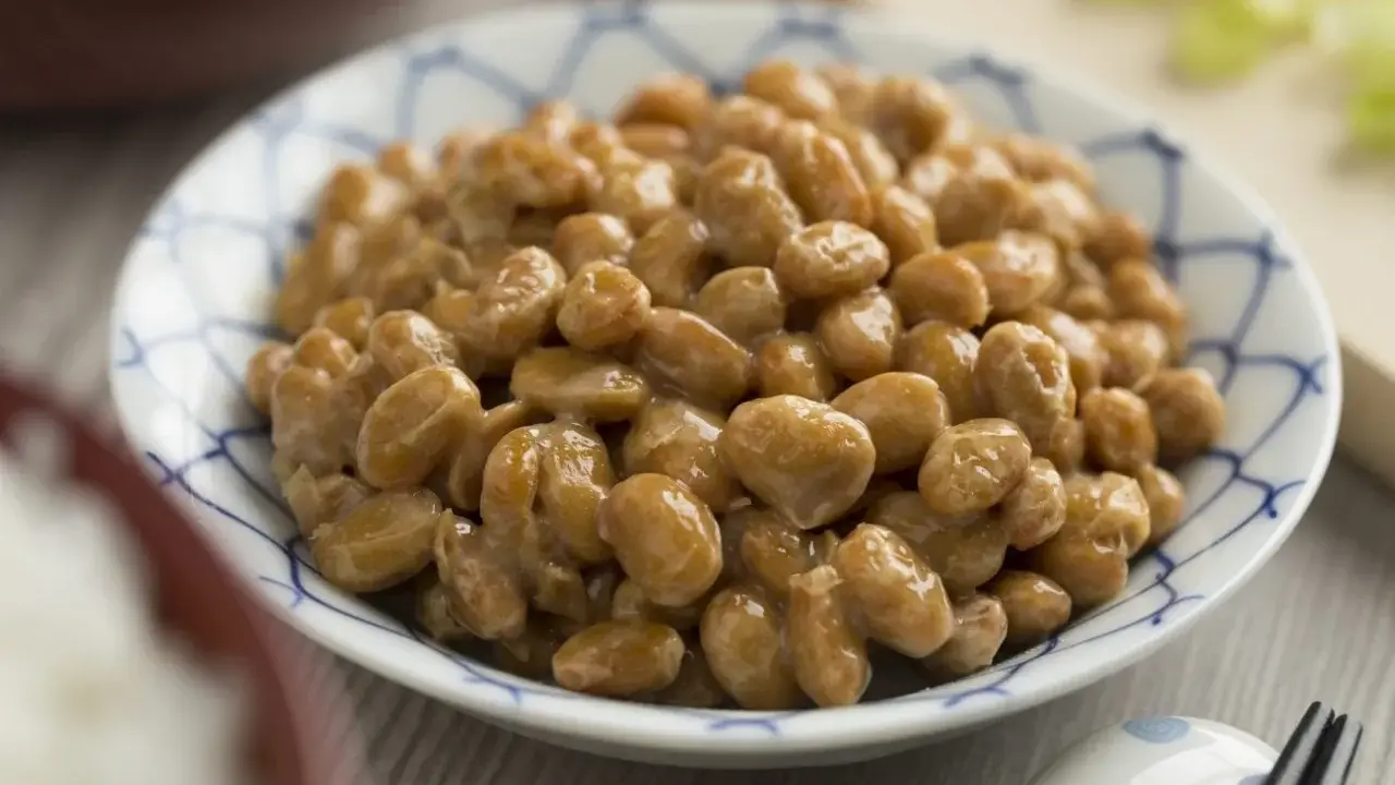 Nattokinaza na co pomaga? Miseczka sfermentowanej soi, czyli natto, z charakterystyczną nitkowatą konsystencją.