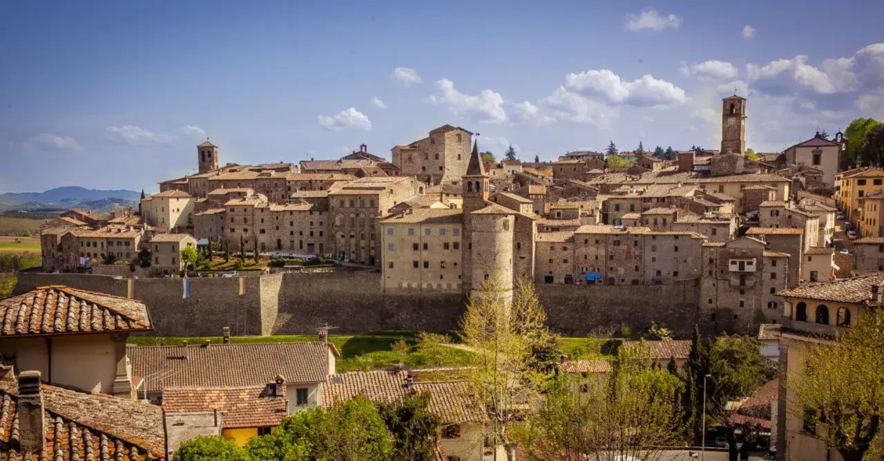 Panoramica di un borgo medievale toscano, con case in pietra e tetti in cotto, che si estende su una collina. Una dettagliata cartina borghi toscana potrebbe mostrare questo luogo.