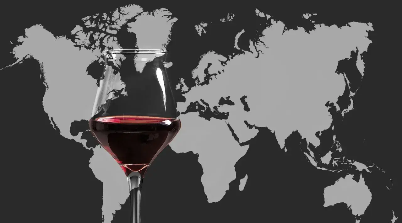 Ein Glas Rotwein vor einer Weltkarte. Die Vielfalt der Appellationen weltweit lädt zum Entdecken ein.
