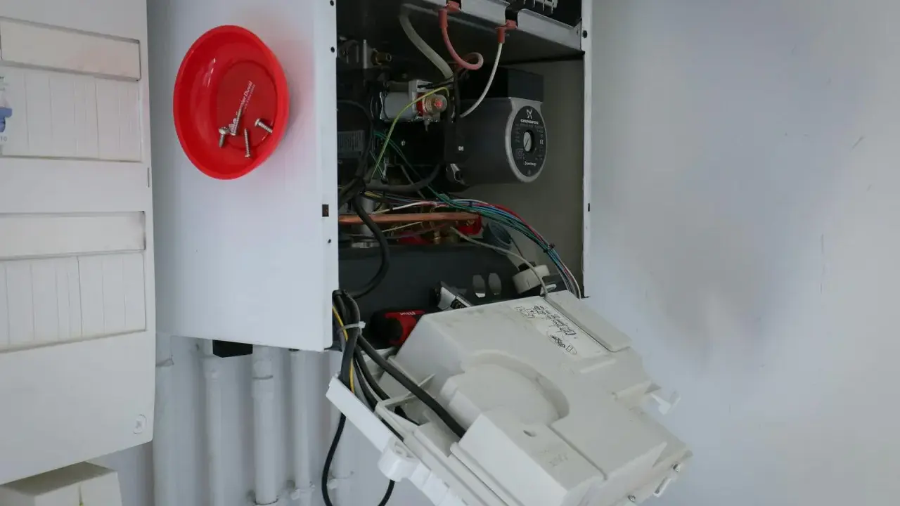 Ouvert pour l'entretien chaudière gaz obligatoire, on voit le circuit électrique et la pompe.