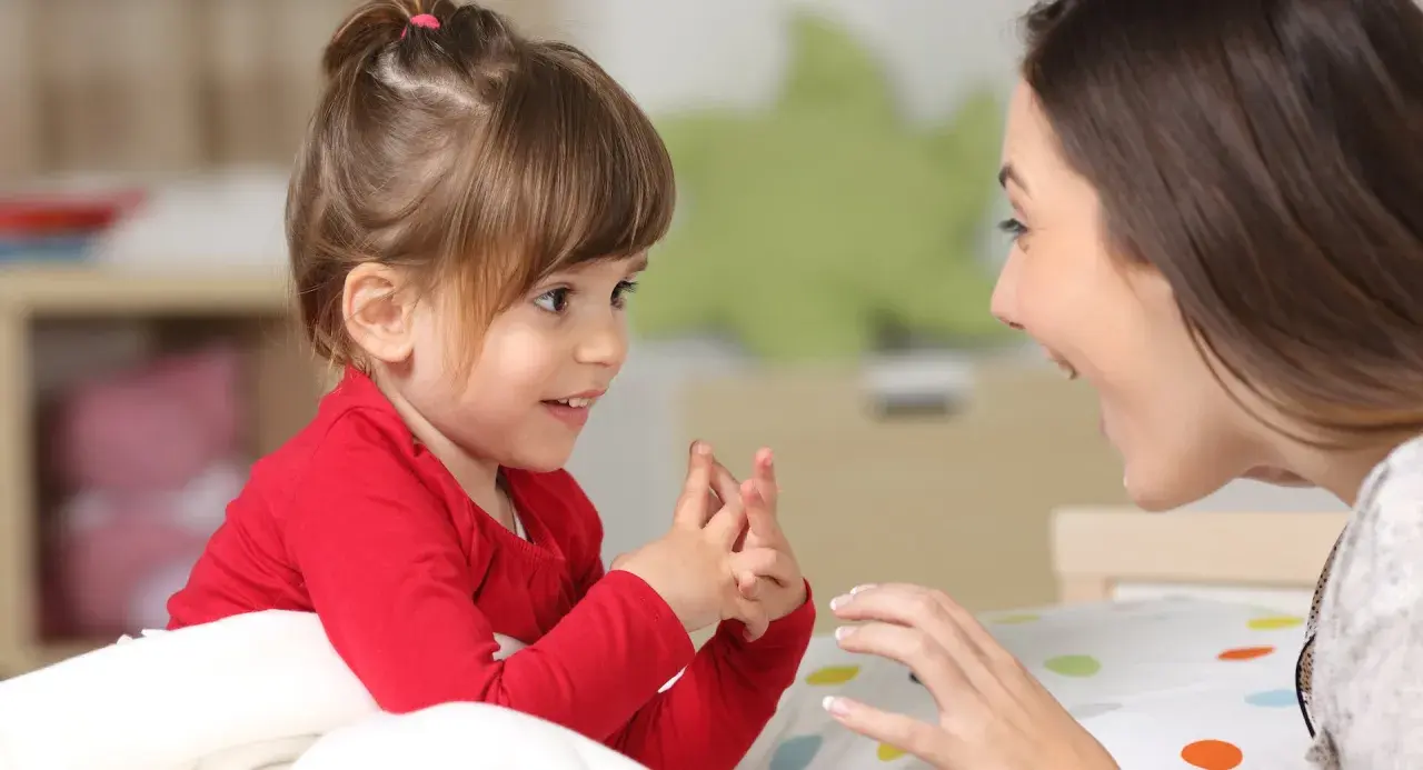 Ein kleines Mädchen und eine Frau sprechen liebevoll miteinander. Dies zeigt, welche erziehungsstile es gibt, wie z.B. den autoritativen Stil.