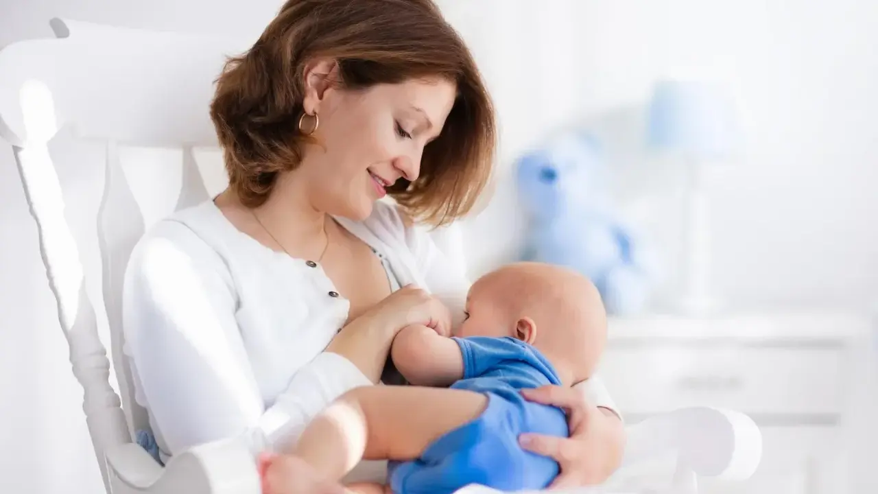 Mama karmi piersią dziecko na bujanym fotelu. Czy to powód, dlaczego dziecko ulewa?