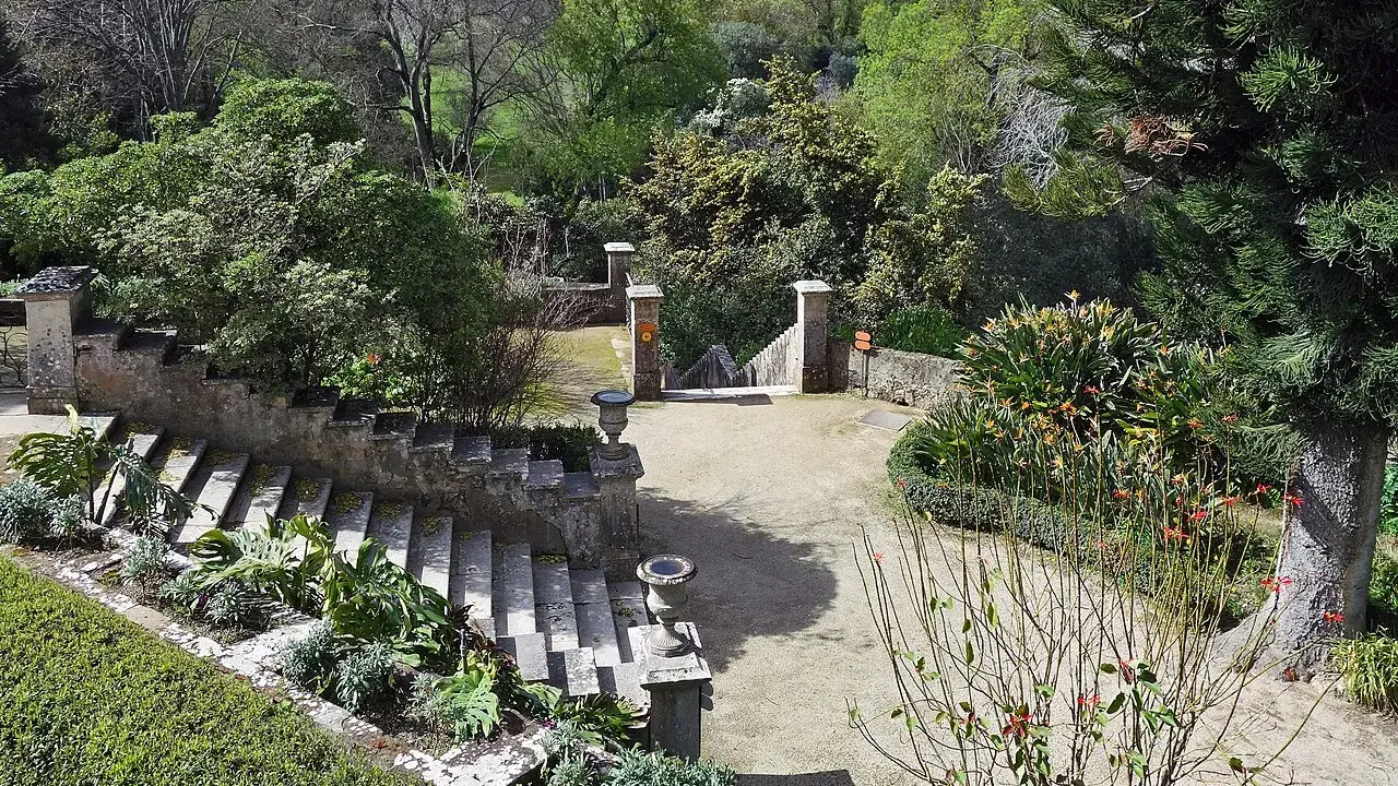 Steintreppen und üppige Vegetation in einem botanischen Garten mit Blick auf Lissabon.
