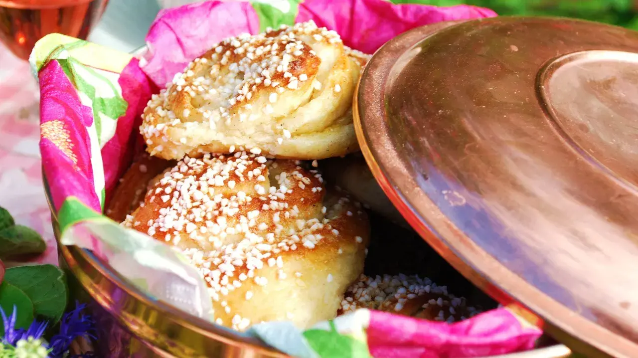 Nybakade vaniljbullar med pärlsocker i en fin burk, redo att avnjutas. Ett perfekt recept för fika.