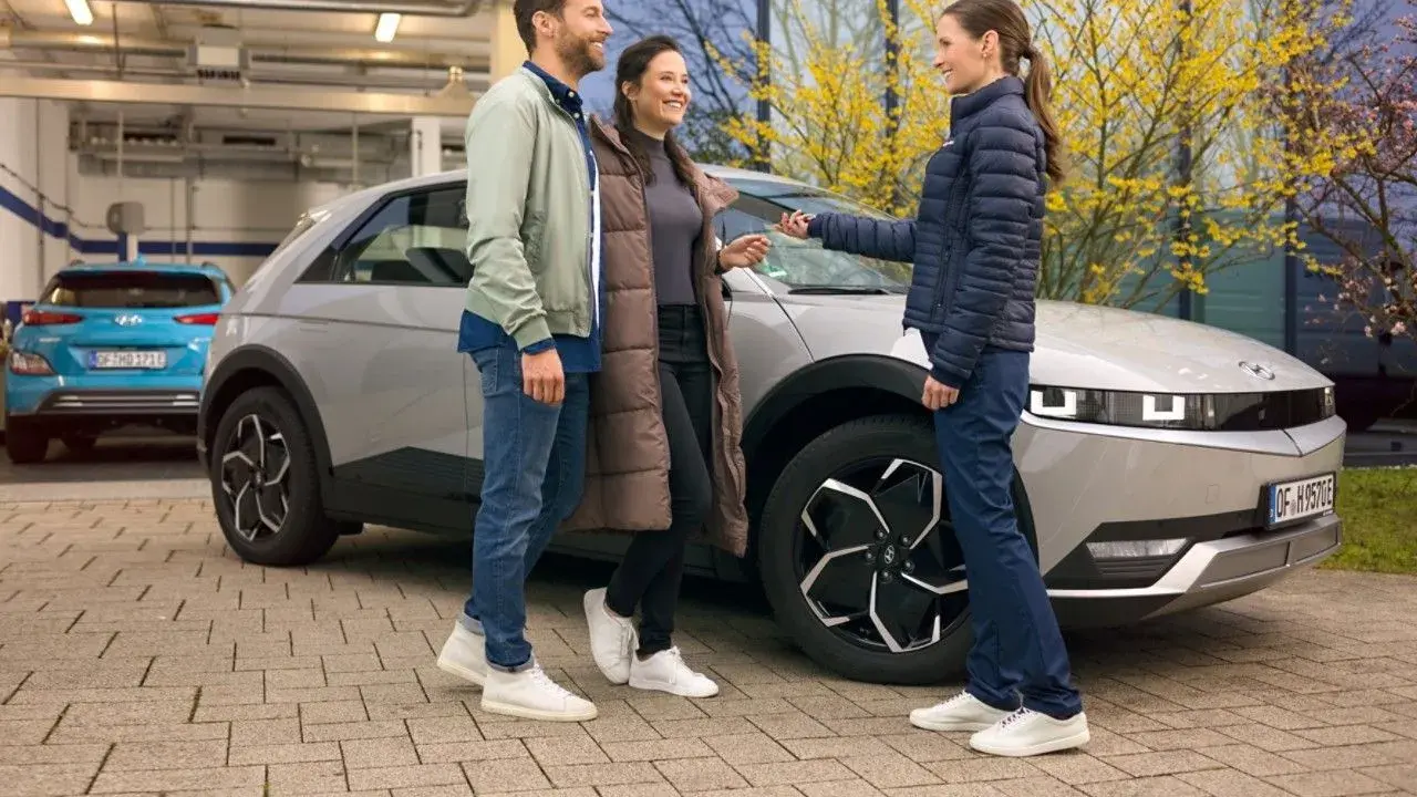 Para sprawdzająca hyundai serwis cennik odbiera kluczyki od pracownicy serwisu.